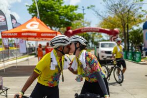 couple kisses at the end of a bike race. Image for blog post about intentionally planning out your summer in Portland, OR. Core Values Counseling.