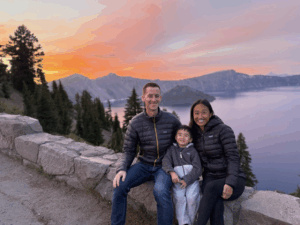 photo of Cameron Madill and wife and child with mountains and sunset in background