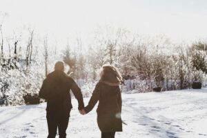 Image of a man and woman holding hands, dressed in winter clothers, walking away from camera on a snowy day. Image for Core Values Counseling blog post about relationships.