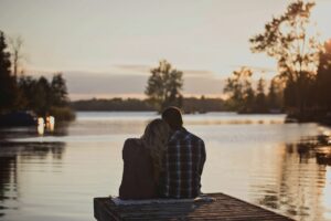 Image of a couple sitting at the end of the dock, watching the sunrise. For an article about substance abuse/addiction recovery by Sabrina Walters of Core Values Counseling.