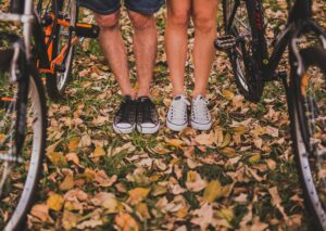 image of two pairs of legs with sneakers on, side by side, with bikes next to them. For a blog post by Sabrina Walters of Core Values Counseling, about couples playing together.